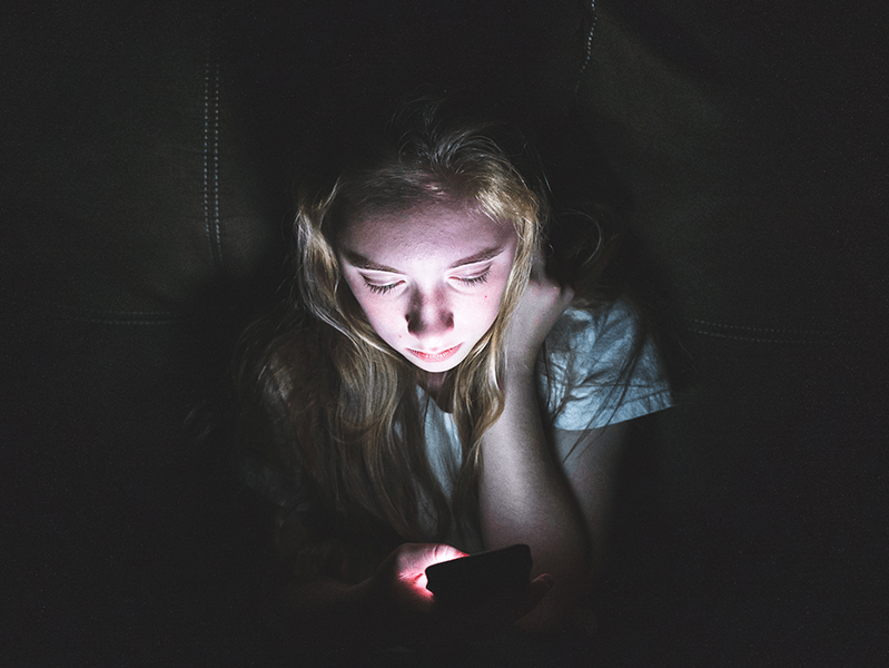 girl in dark room on phone