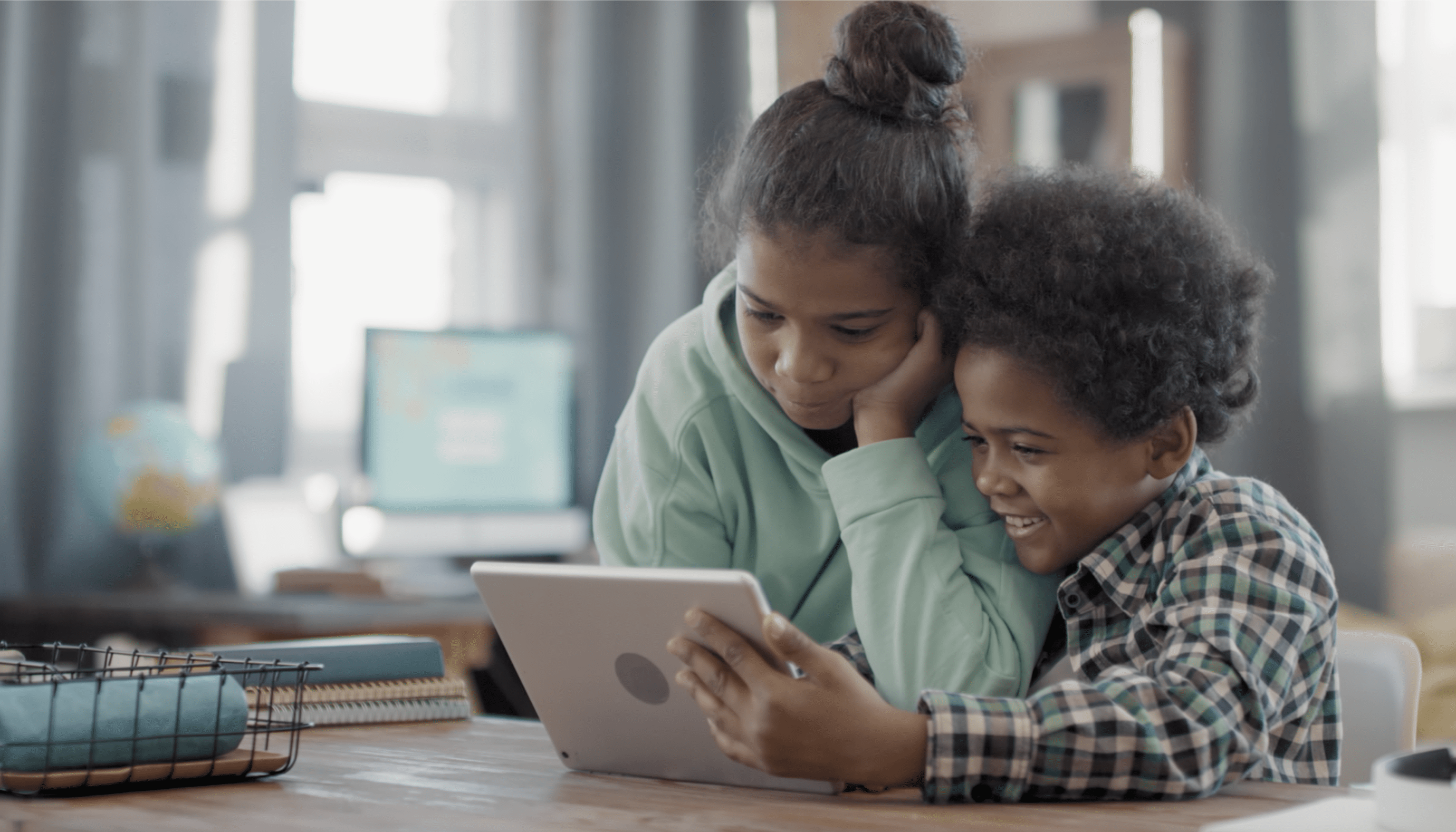Image of a young boy and a young girl looking at a smart tablet