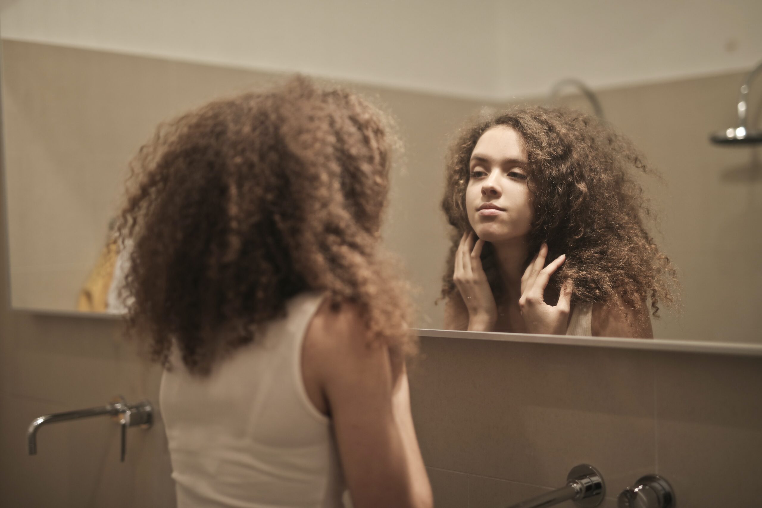 woman looking at herself in the mirror