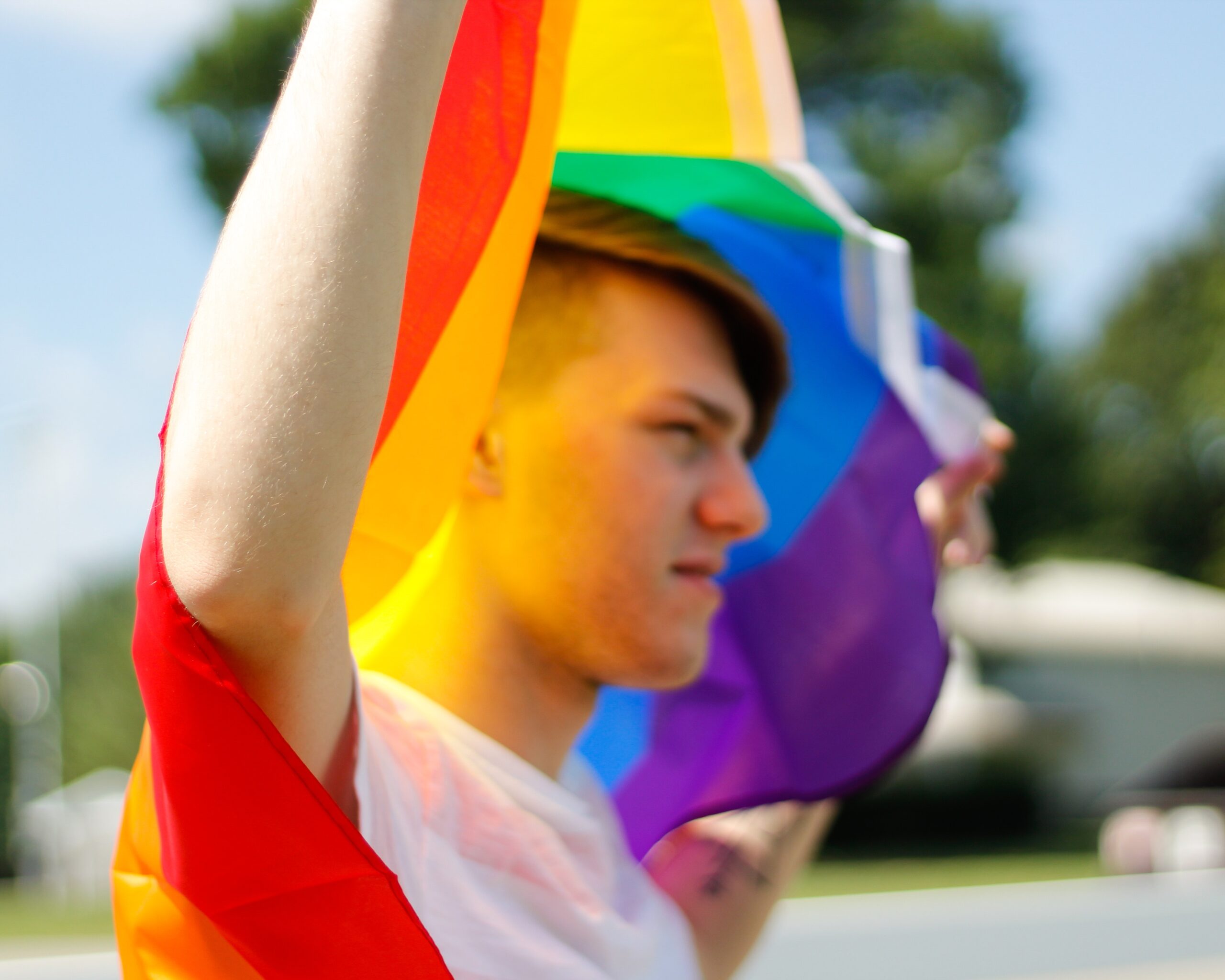 young boy holding a rainbow flag