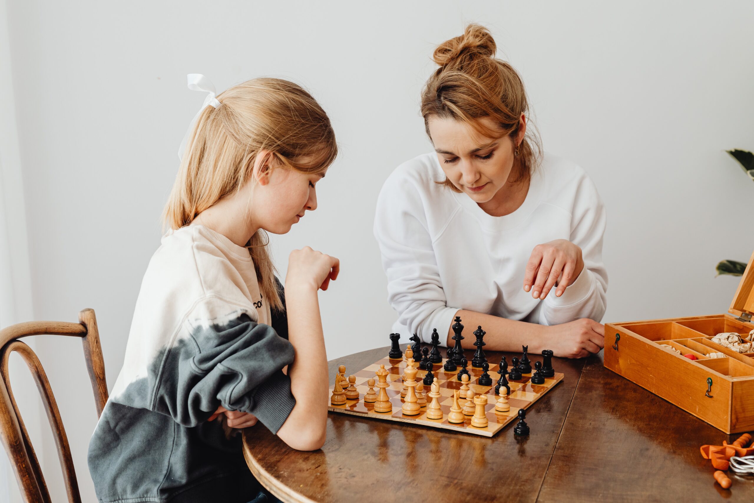 Mum and Daughter playing chess at a table